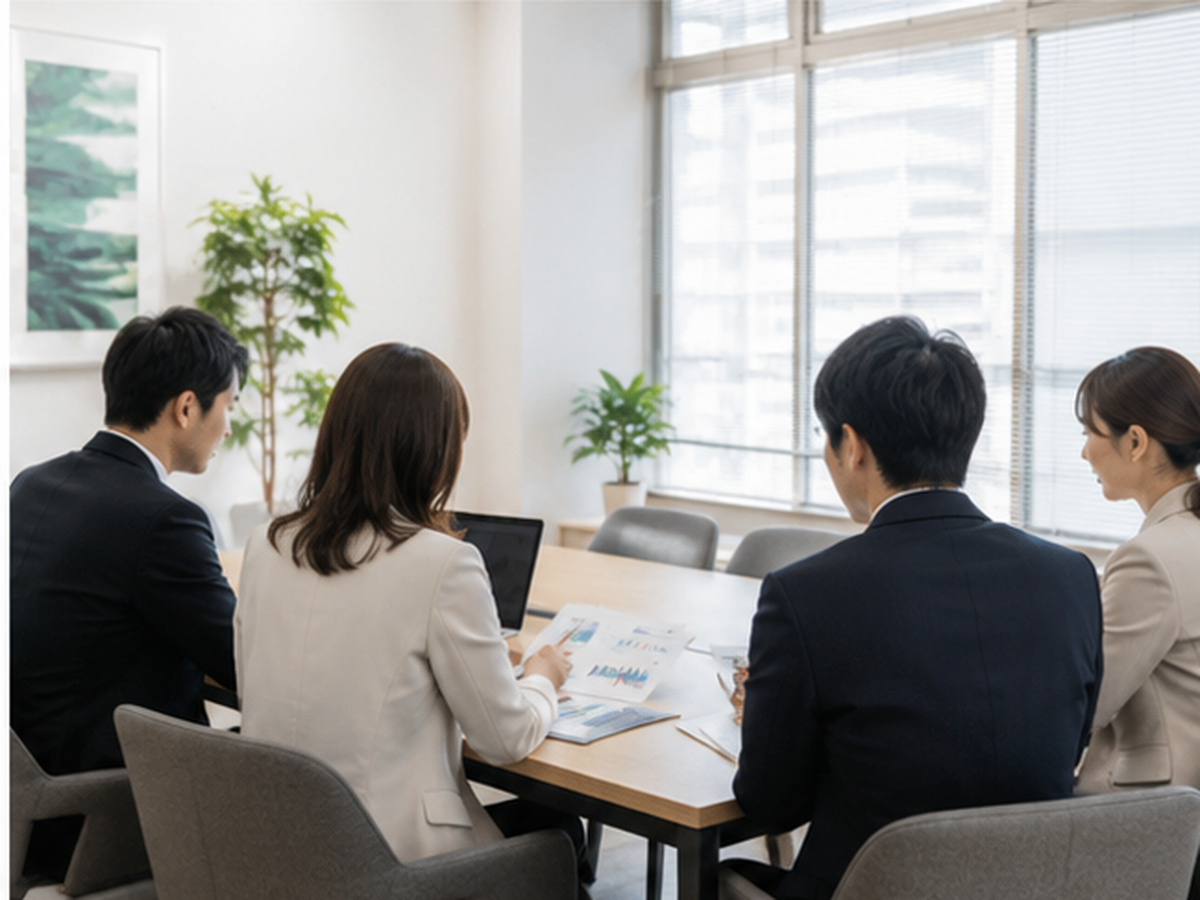 明るい会議室で事業資料を確認するチーム